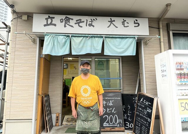 『立喰そば 大むら』の店頭に立つ店長を撮影した画像。元トラック運転手。(撮影は編集部)